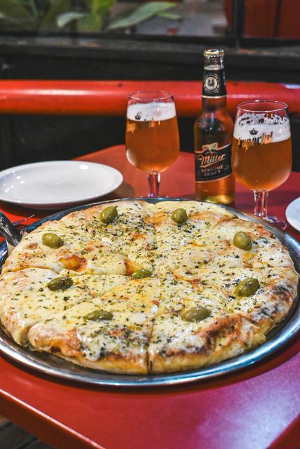 Muzzarella a la piedra con aceitunas y cervezas en la mesa