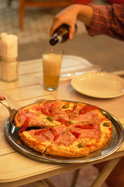 Pizza de jamón y morrones a la piedra con cerveza